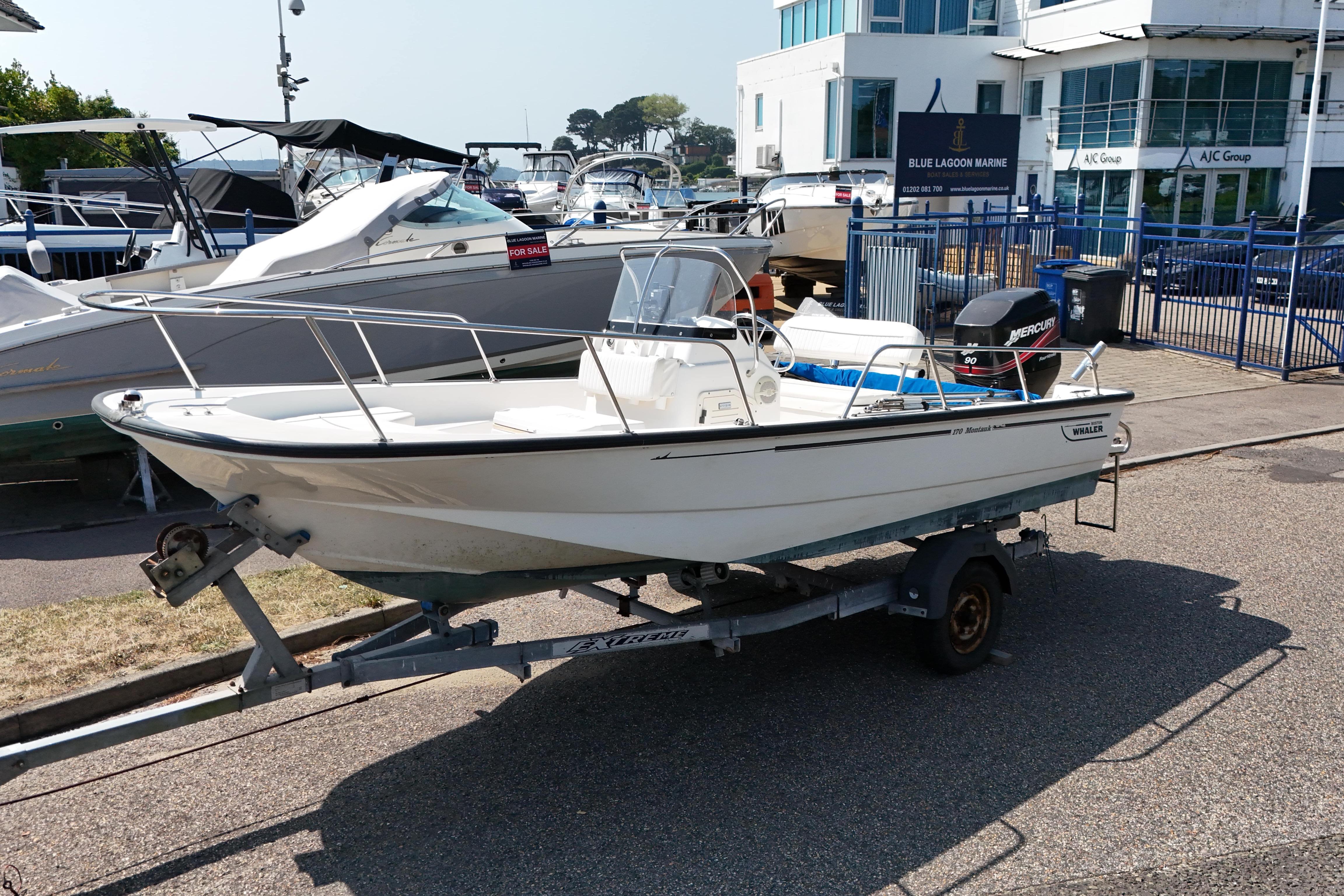 Boston Whaler 170 Montauk 2004 Boston Whaler 170 Montauk boat on trailer, parked near marina.