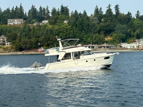 Beneteau Swift Trawler 41 Fly 2022 Beneteau Swift Trawler 41 Fly cruising on a scenic lake with forested shoreline.