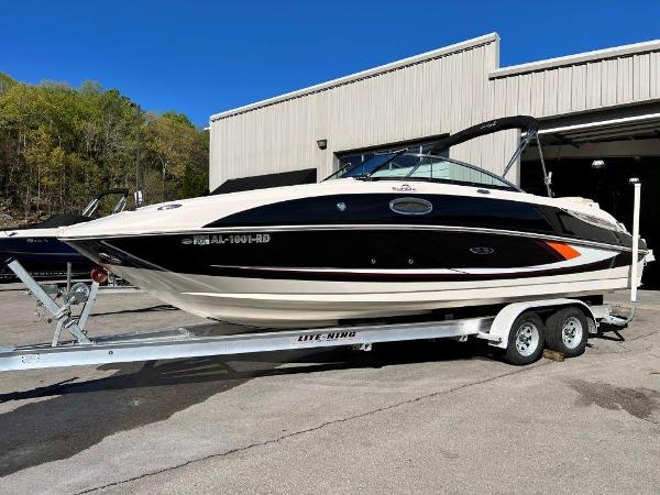 Sea Ray 260 Sundeck 2013 Sea Ray 260 Sundeck boat on a trailer outside a warehouse.