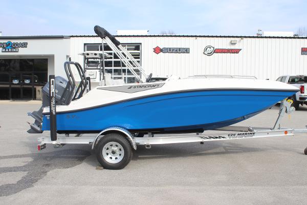 Starcraft SV 16 OB 2025 Starcraft SV 16 OB boat on trailer, blue and white, parked outside marine dealership.