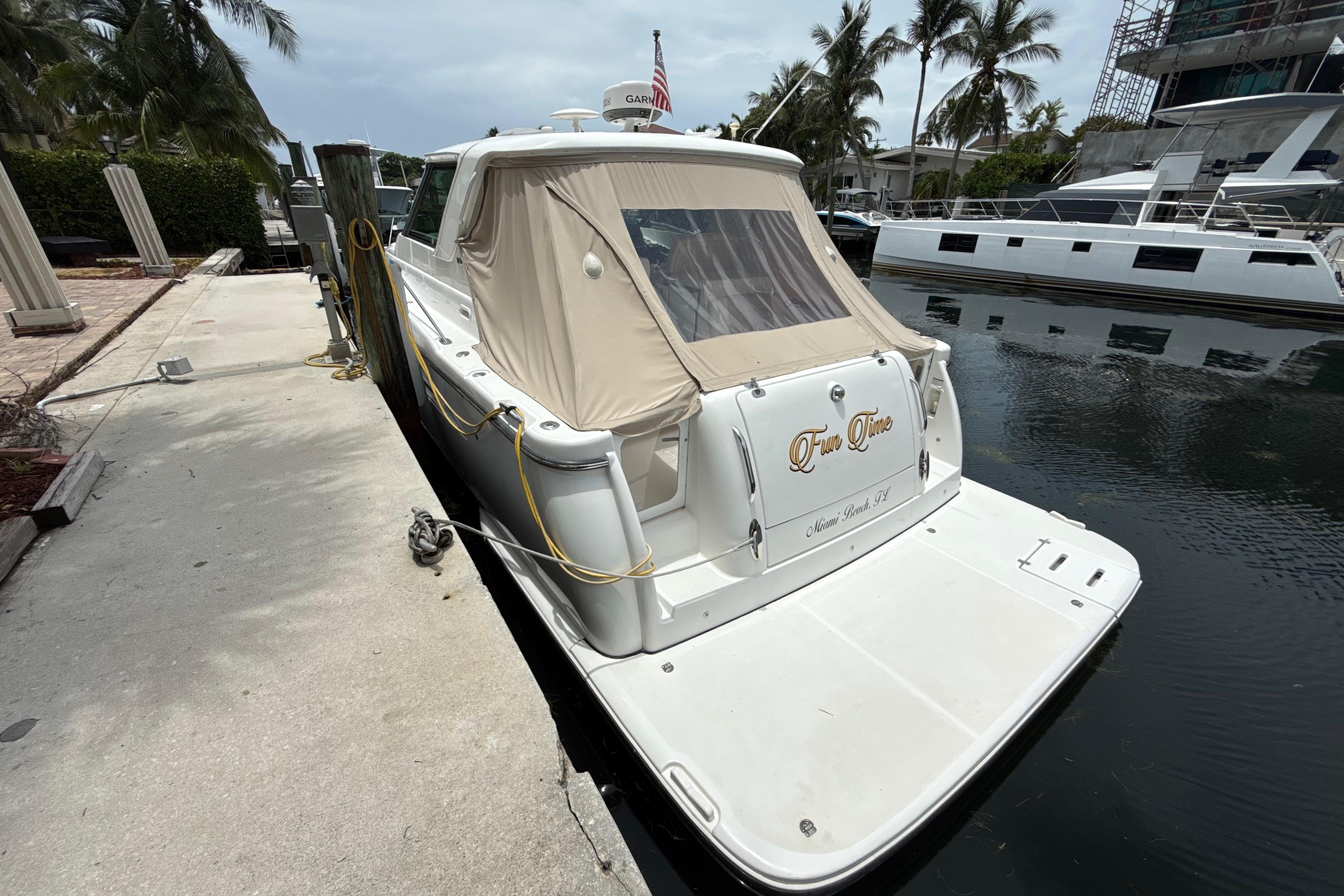 Tiara Yachts 3600 Sovran 2005 Tiara Yachts 3600 Sovran docked, rear view with beige cover, palm trees in background.