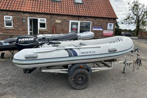 Highfield CL340 Package 2016 Highfield CL340 inflatable boat on trailer with Evinrude motor, parked outside dealership.