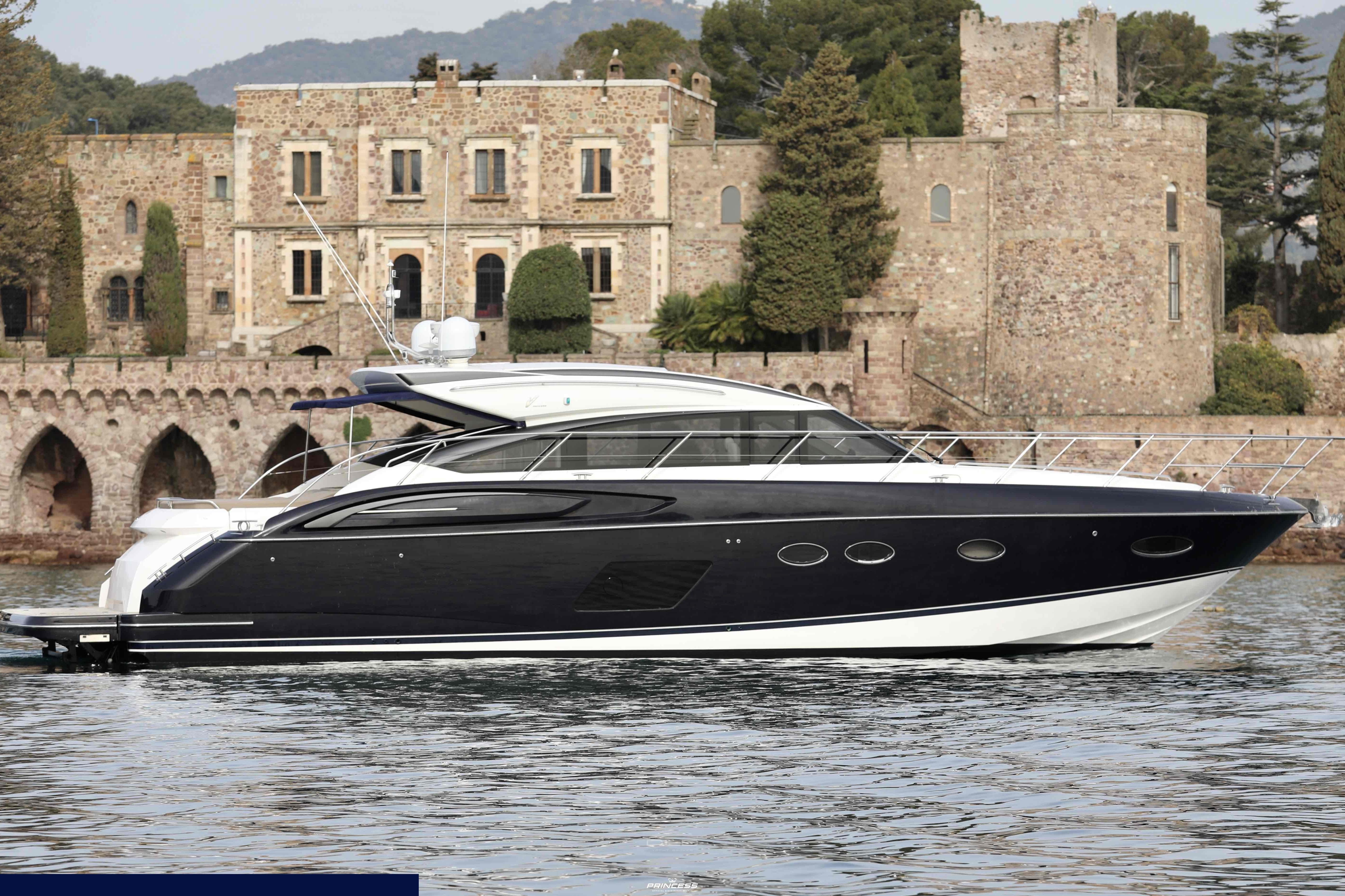 Princess V57 Luxurious 2013 Princess V57 yacht cruising near a historic stone building.