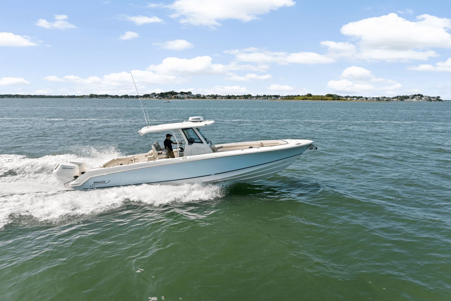 Boston Whaler 330 Outrage 2025 Boston Whaler 330 Outrage cruising on open water under a clear sky.