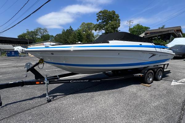 Crownline 240 SS 2023 Crownline 240 SS boat on trailer in parking lot, sunny day.