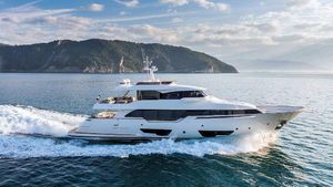 Custom Line Navetta 28 Luxurious 2016 Custom Line Navetta 28 yacht cruising on serene waters near a scenic coastline.
