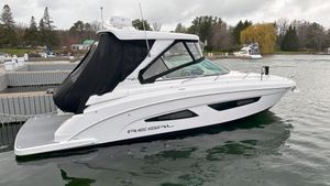 Regal 33 Express 2021 Regal 33 Express boat docked on a calm lake with overcast skies.