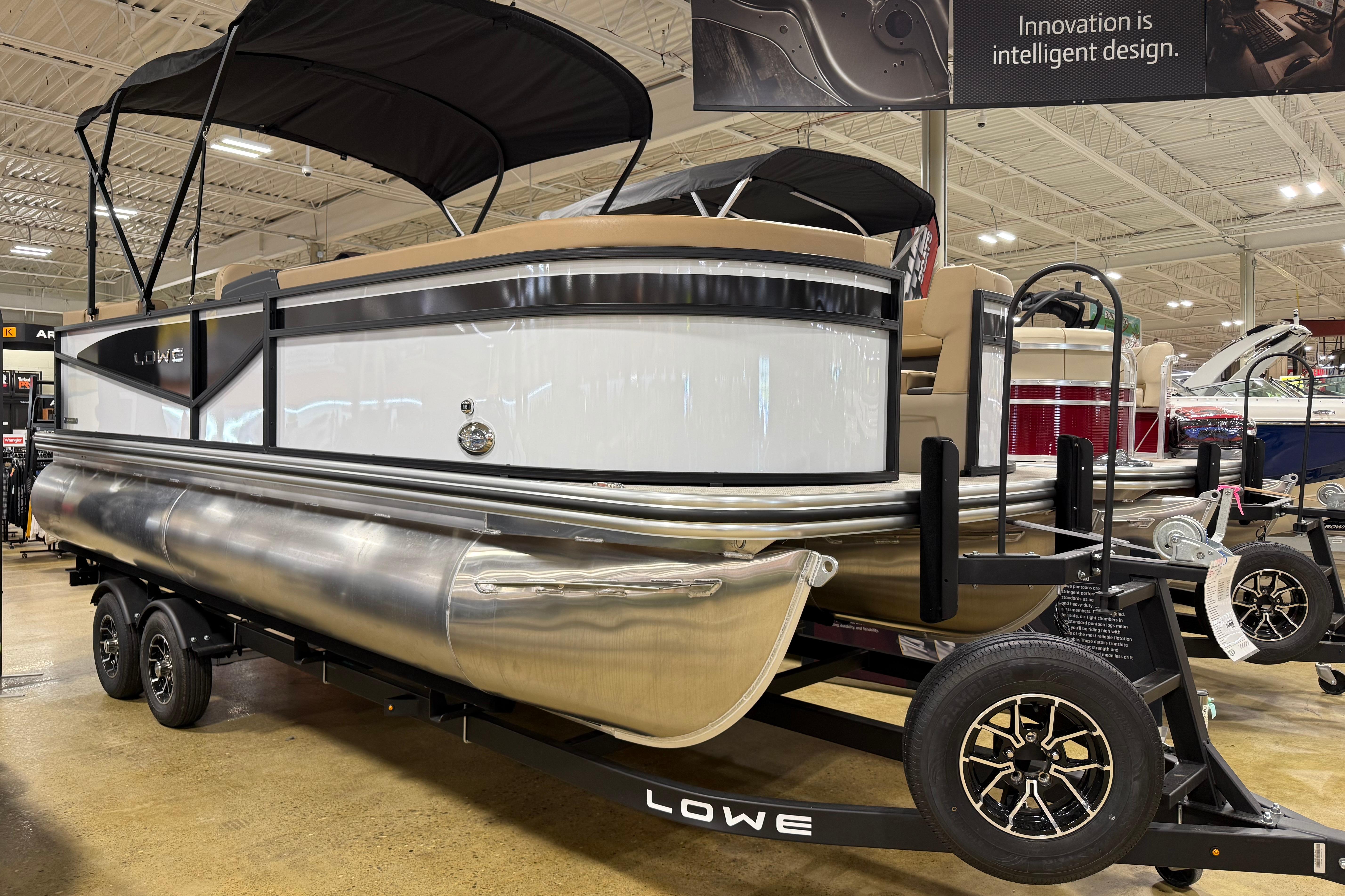 Lowe LS 210 2026 Lowe LS 210 pontoon boat displayed indoors, showcasing sleek design and modern features.