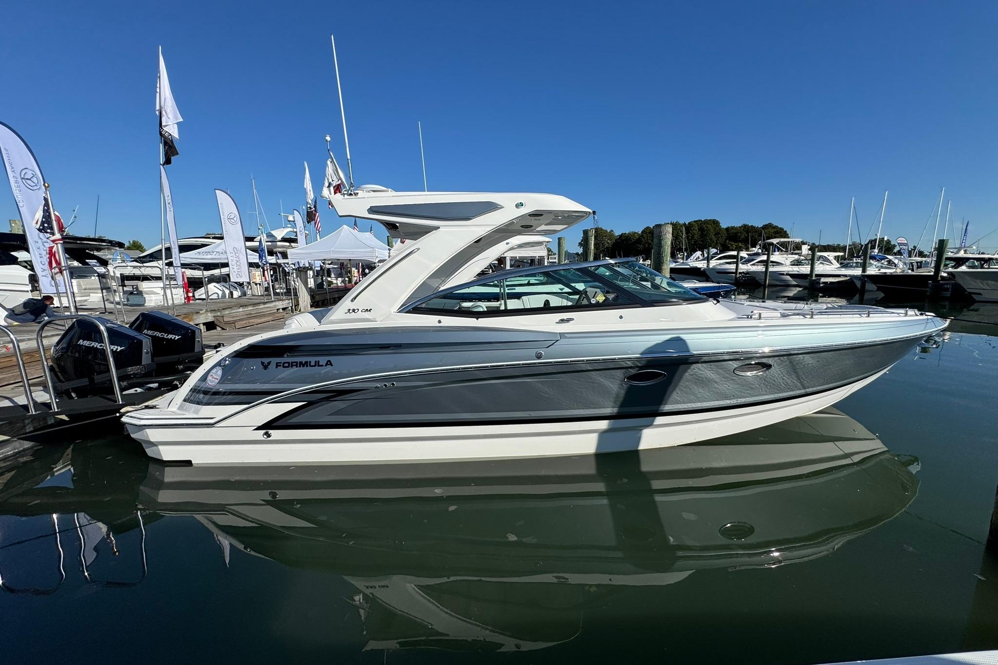 Formula 330 Crossover Bowrider OB 2026 Formula 330 Crossover Bowrider OB docked at marina under clear blue sky.