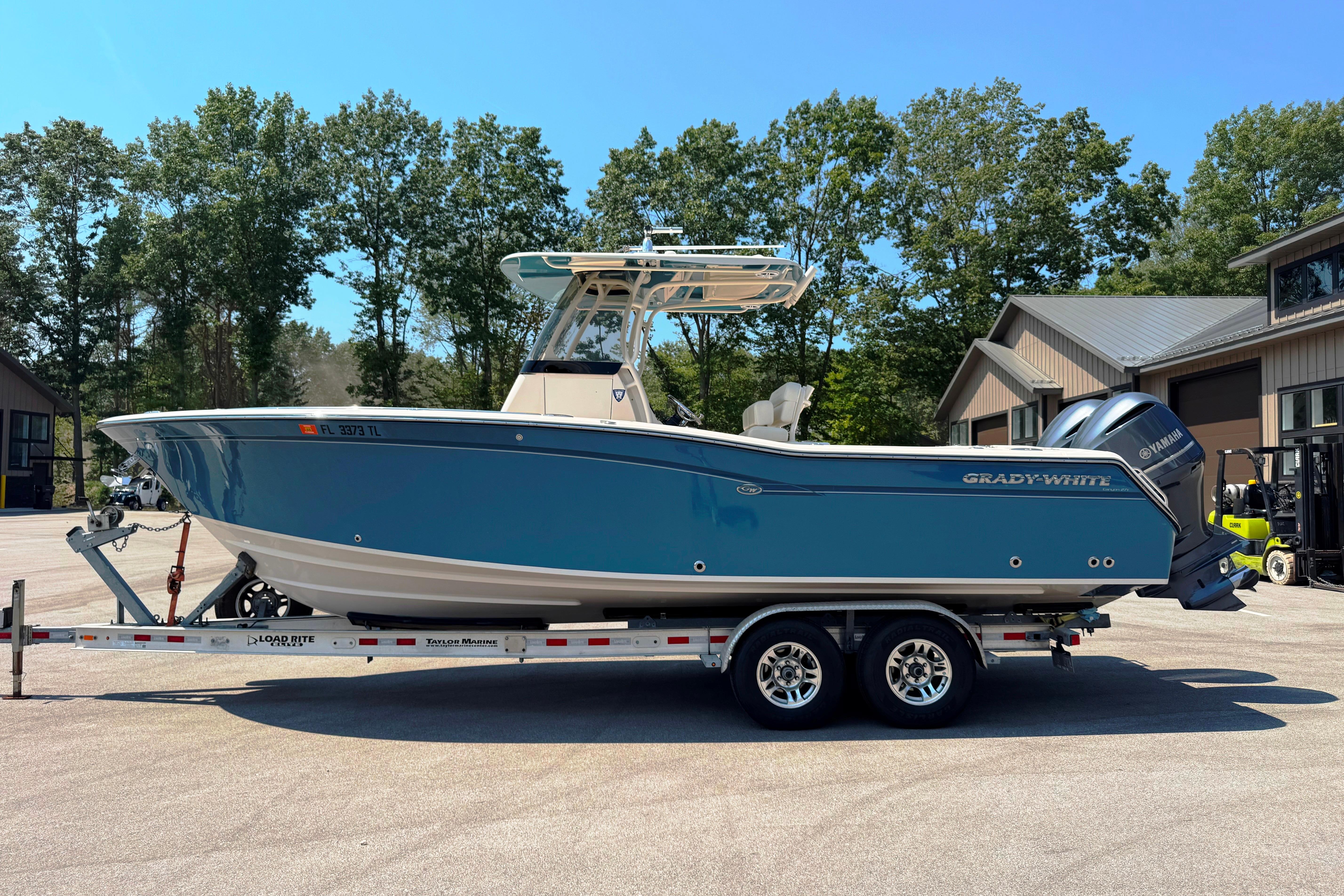 Grady-White Canyon 271 2019 Grady-White Canyon 271 boat on trailer, parked outdoors near buildings and trees.