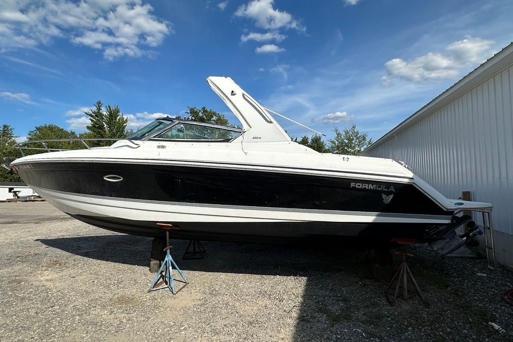 Formula 280 Sun Sport 2005 Formula 280 Sun Sport boat on stands, outdoors, under a blue sky.