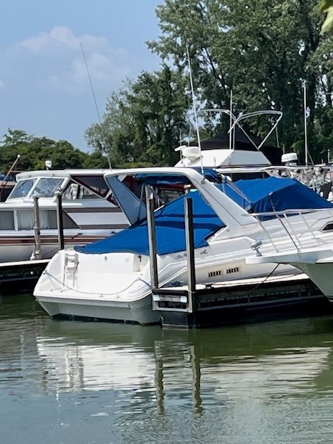 Sea Ray Sundancer 310 1991 Sea Ray Sundancer 310 docked with blue covers, surrounded by trees and water.