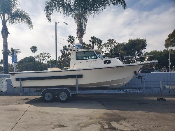 Parker 25 Sport Cabin 1996 Parker 25 Sport Cabin boat on trailer, parked near palm trees.