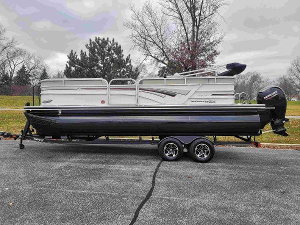 Ranger Reata 223C 2023 Ranger Reata 223C pontoon boat on trailer in a park setting.