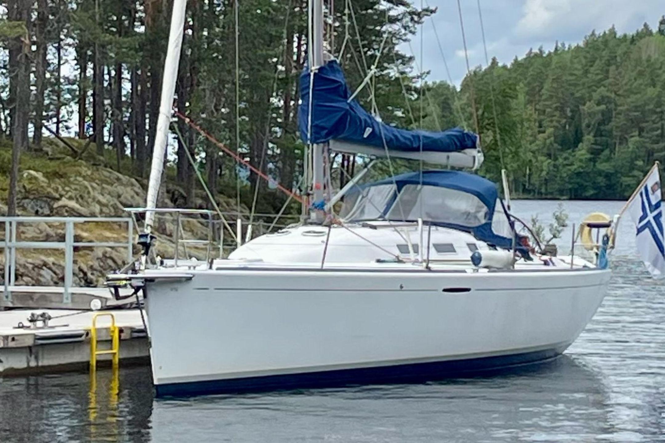 Beneteau First 40.7 Beneteau First 40.7 sailboat docked by a forested shoreline, 2000 model.