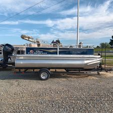 Sun Tracker Bass Buggy 16 XL Select 2025 Sun Tracker Bass Buggy 16 XL Select pontoon boat on trailer, parked outdoors.