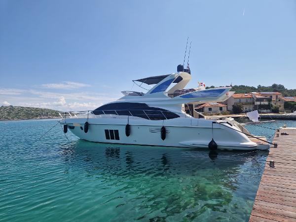 Azimut 60 Azimut 60 yacht, 2013 model, docked in clear turquoise water.