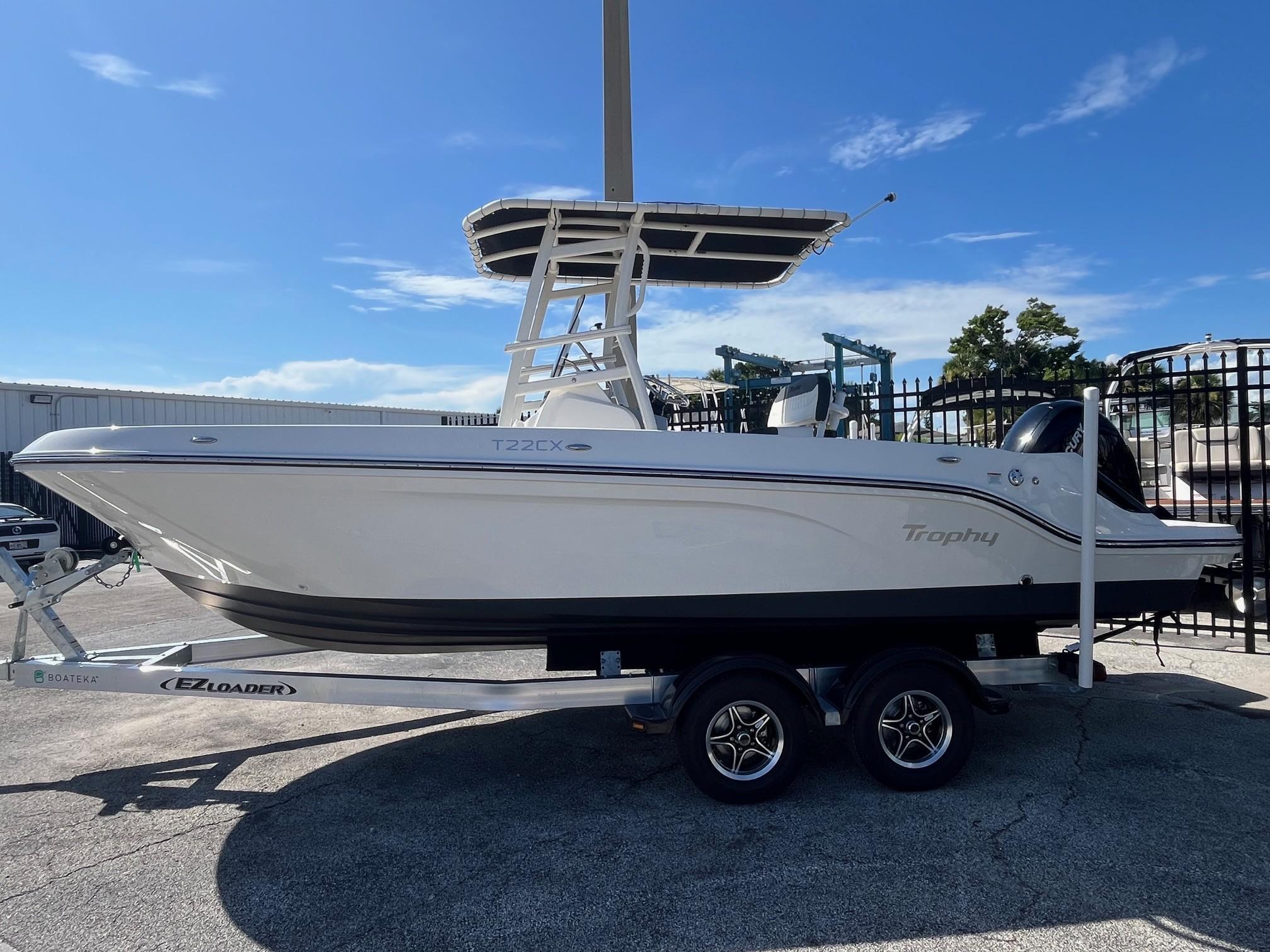 Bayliner Trophy T22CC 2023 Bayliner Trophy T22CC boat on trailer under clear blue sky.