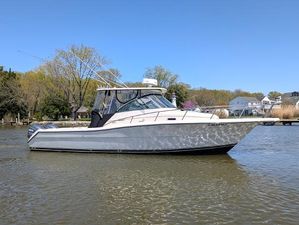 Pursuit 3070 Offshore Center Console 2001 Pursuit 3070 Offshore Center Console boat on calm water, surrounded by trees and houses.