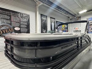 Bennington 25 RSBSE 2025 Bennington 25 RSB pontoon boat displayed in showroom with promotional banners.