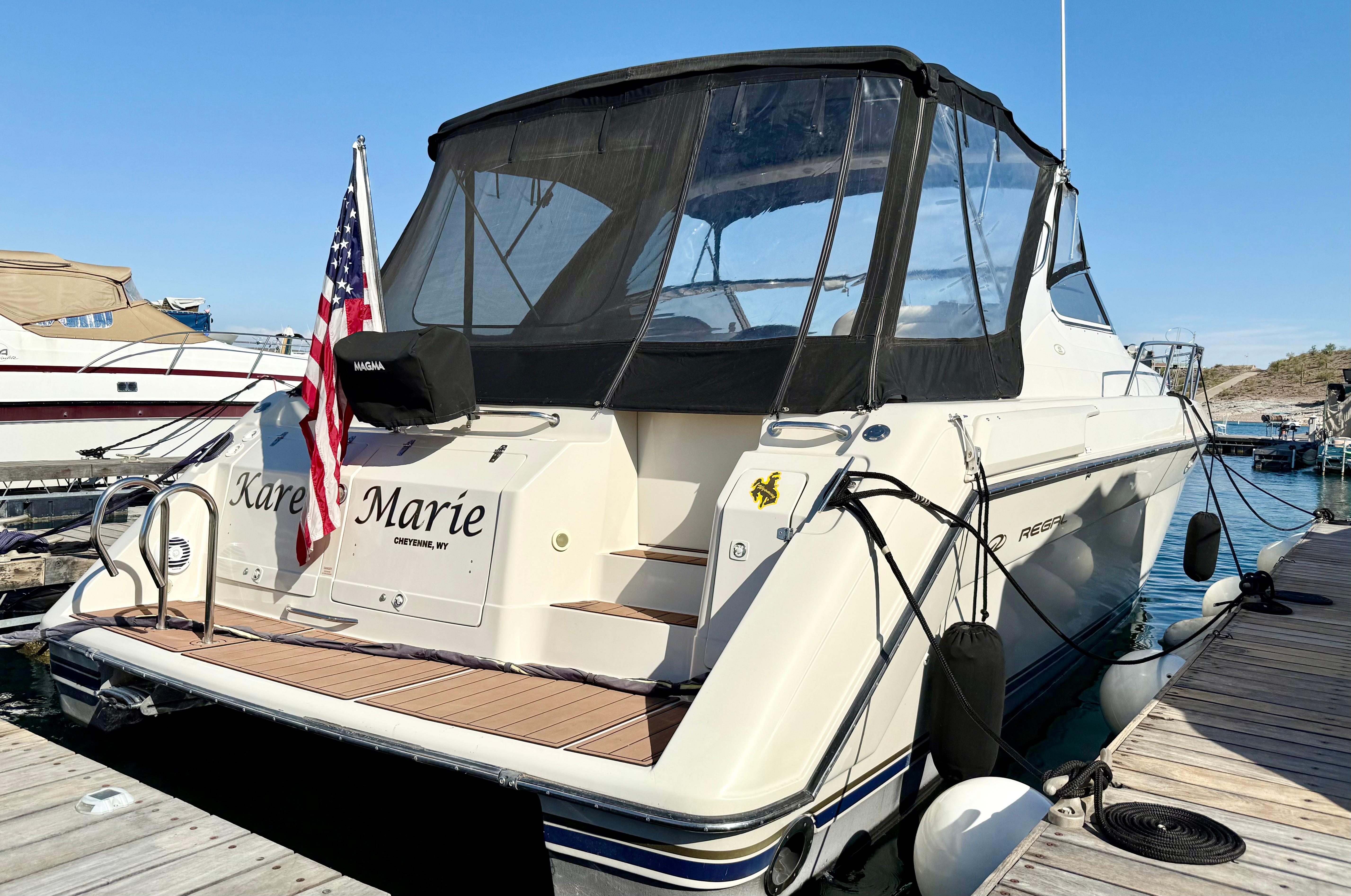 Regal 402 Commodore 1998 Regal 402 Commodore yacht docked, featuring a black canopy and American flag.