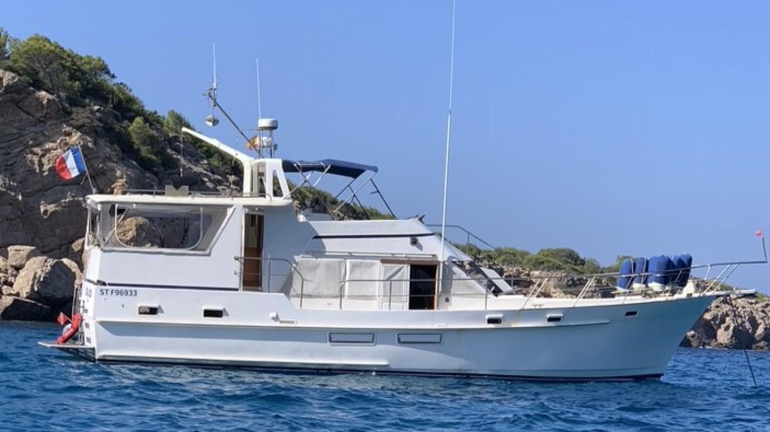 Island Gypsy Island Gypsy 49 1990 Island Gypsy 49 yacht anchored near rocky coastline under clear blue sky.