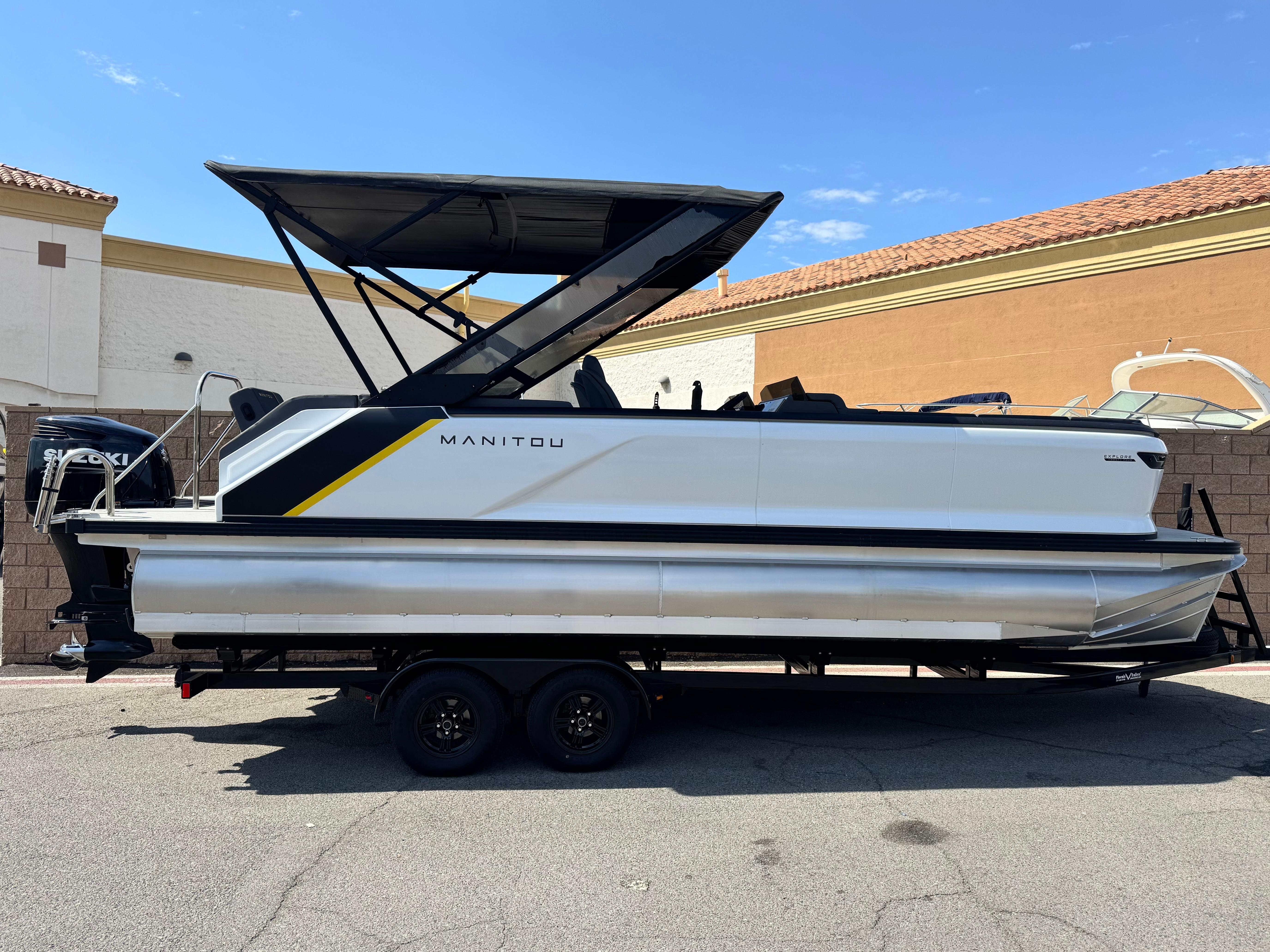 Manitou Explore 24 Navigator 2024 Manitou Explore 24 Navigator pontoon boat on trailer, side view, outdoors.