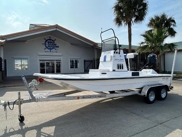 Shallow Stalker Cat 204 2025 Shallow Stalker Cat 204 boat on trailer outside dealership, palm trees in background.