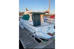 Jeanneau Merry Fisher 805 2002 Jeanneau Merry Fisher 805 docked, featuring a green canopy and white hull.