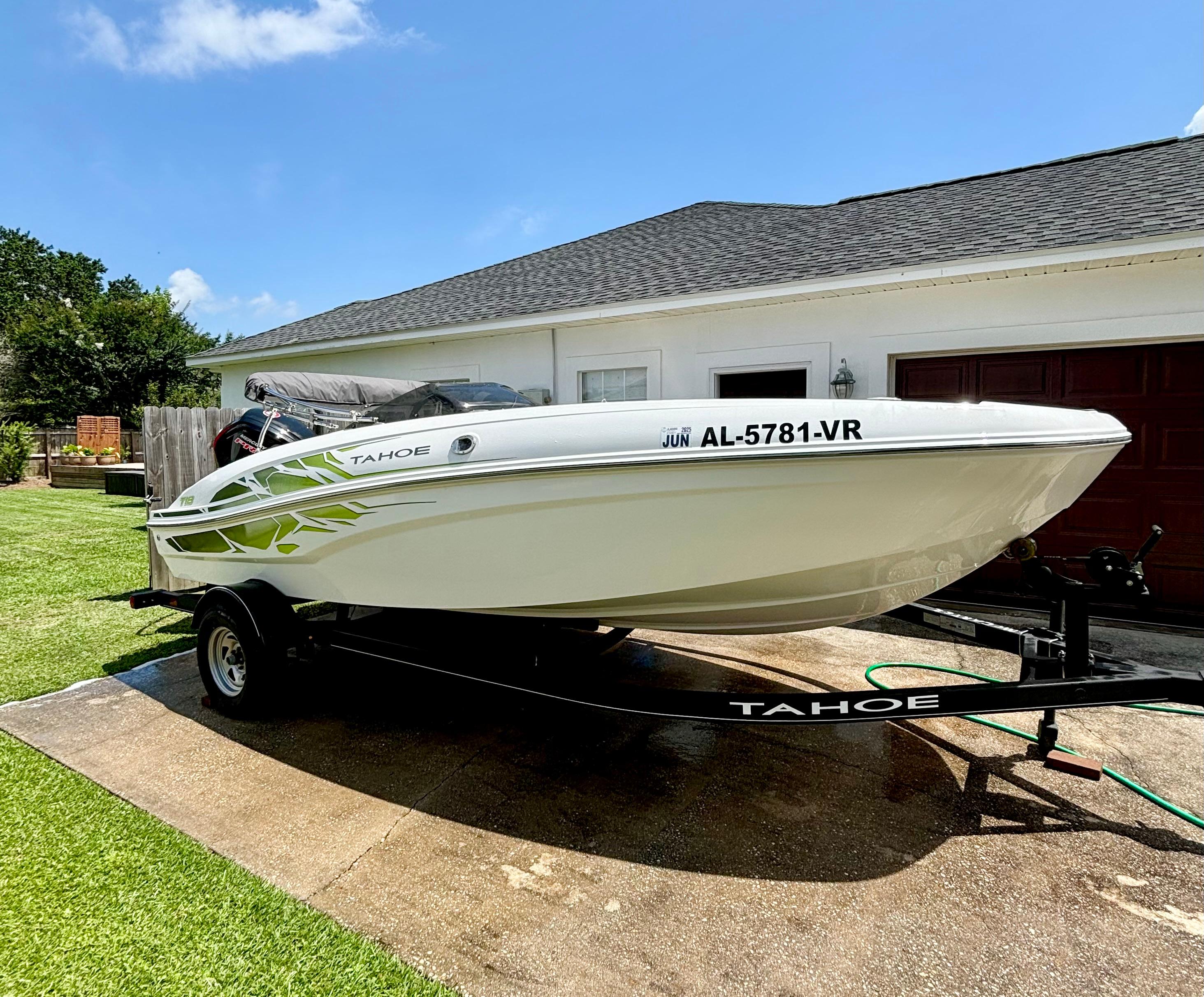 Tahoe T18 2022 Tahoe T18 boat on trailer in driveway, sunny day, green lawn.