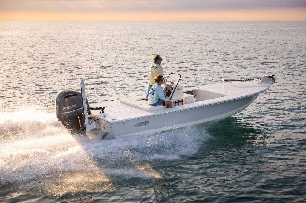 Hewes 21 REDFISHER 2025 Hewes 21 REDFISHER boat cruising on open water at sunset.