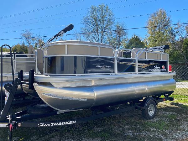 Sun Tracker Party Barge 16 DLX 2025 Sun Tracker Party Barge 16 DLX pontoon boat on trailer, outdoors.