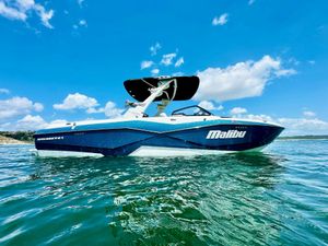 Malibu Wakesetter 25 LSV 2023 Malibu 25LSV boat on water under clear blue sky.