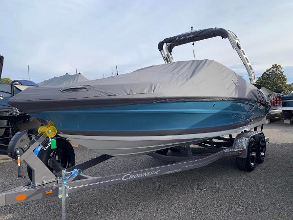 Crownline 240SS 2024 Crownline 240SS boat on trailer with cover, blue hull, and black bimini top.