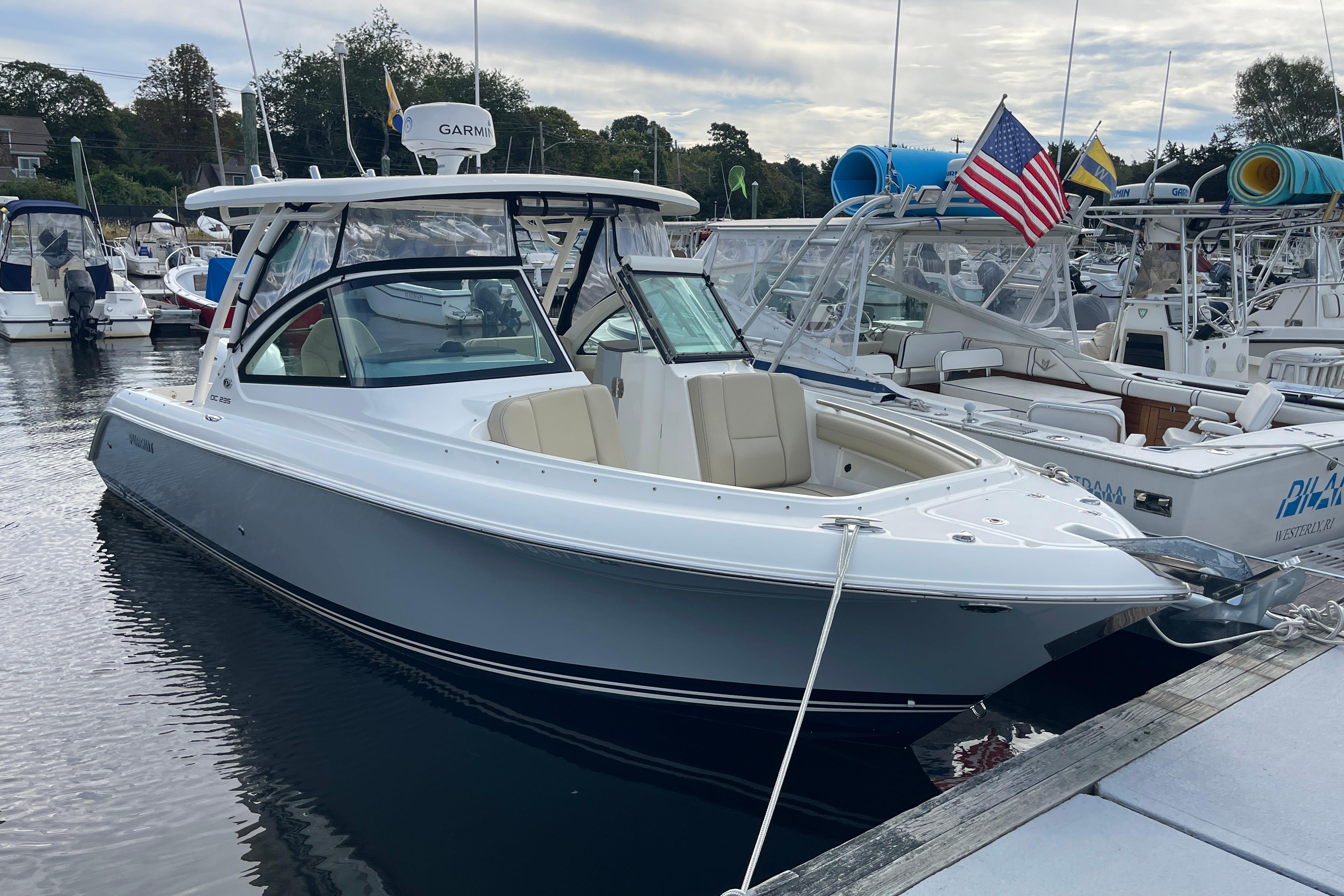 Pursuit DC 235 Dual Console 2020 Pursuit DC 235 Dual Console boat docked in marina, American flag displayed.