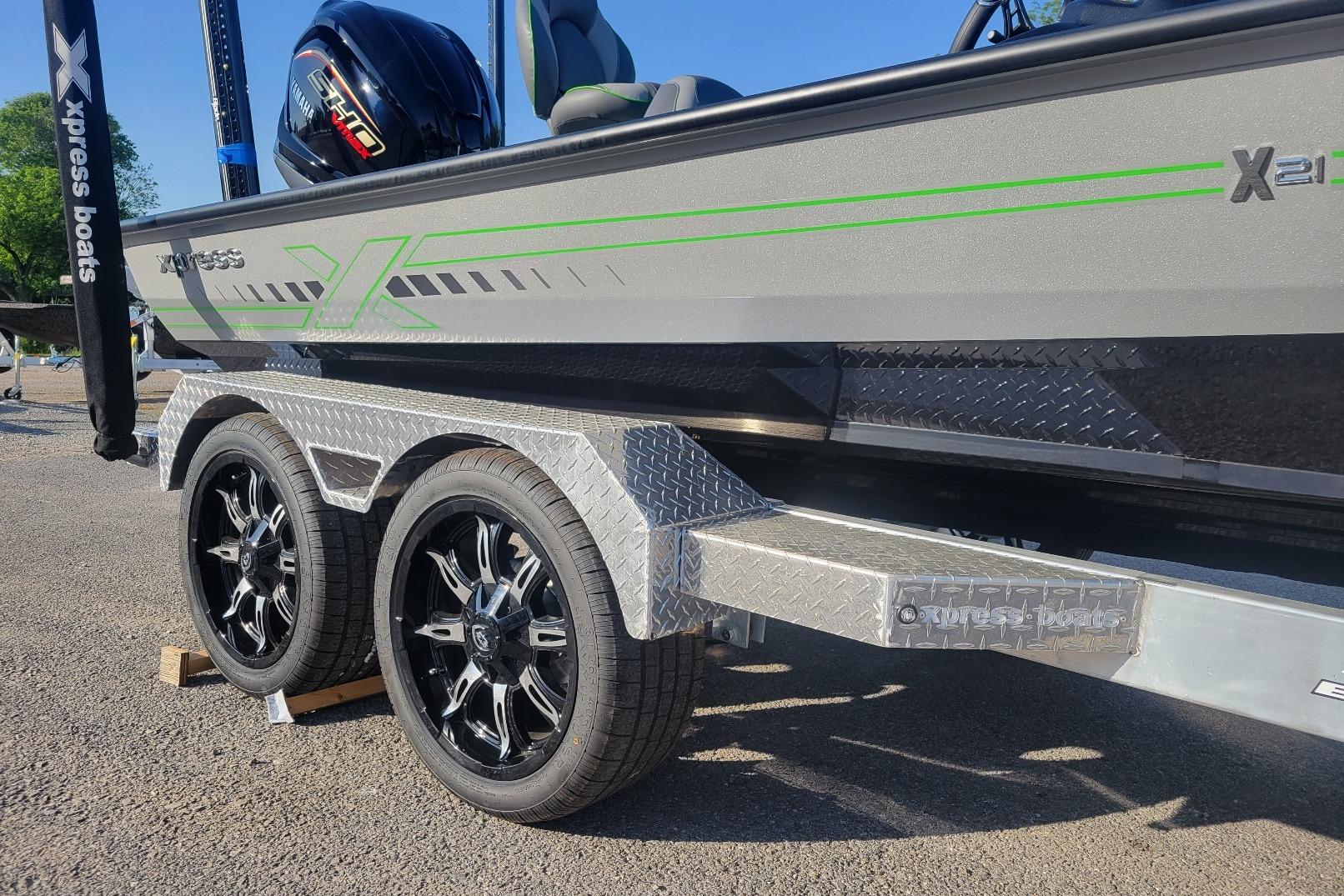 Xpress XR21 2026 Xpress XR21 boat on trailer with stylish wheels and green accents.