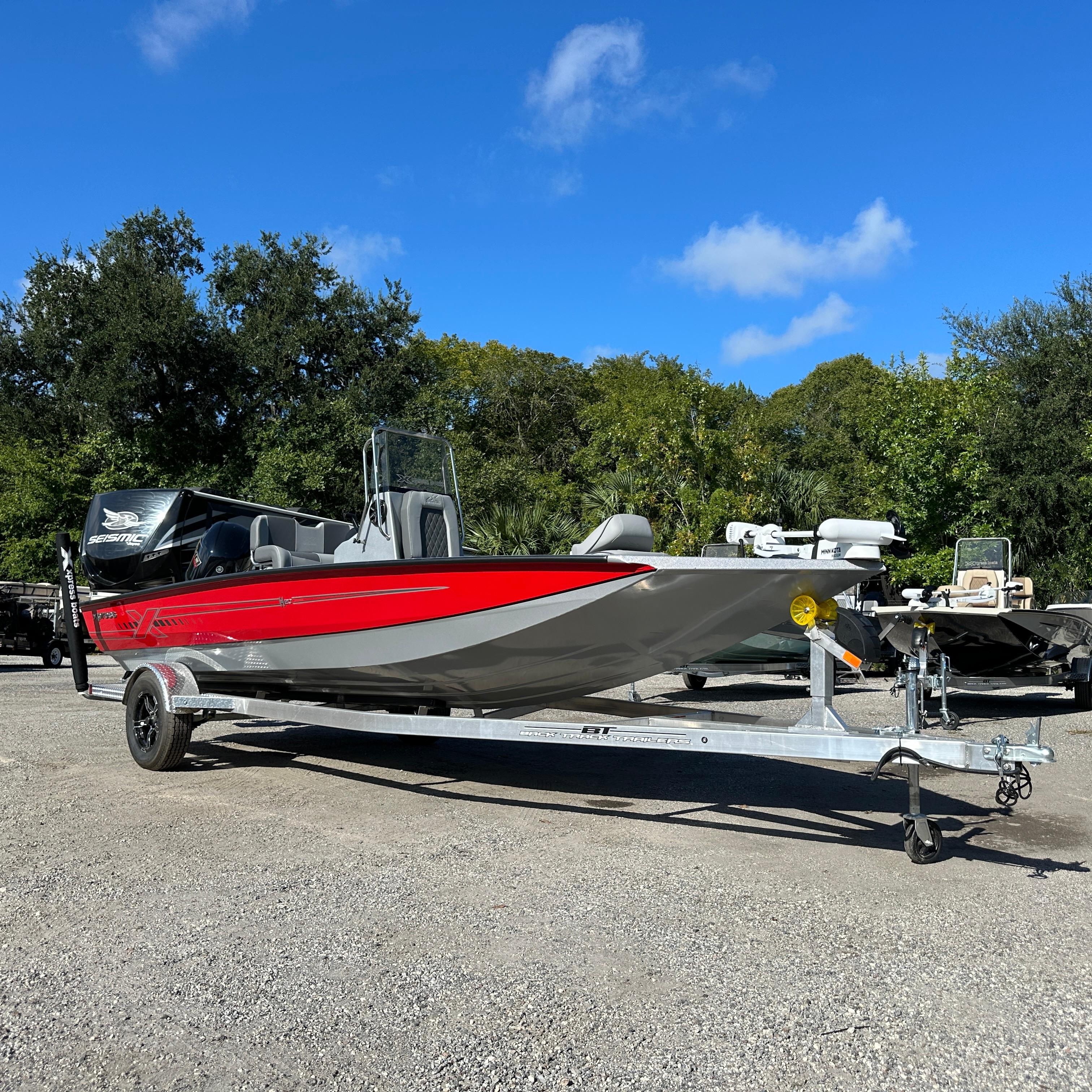 Xpress H20B 2026 Xpress H20B boat on trailer, red and gray design, parked outdoors.
