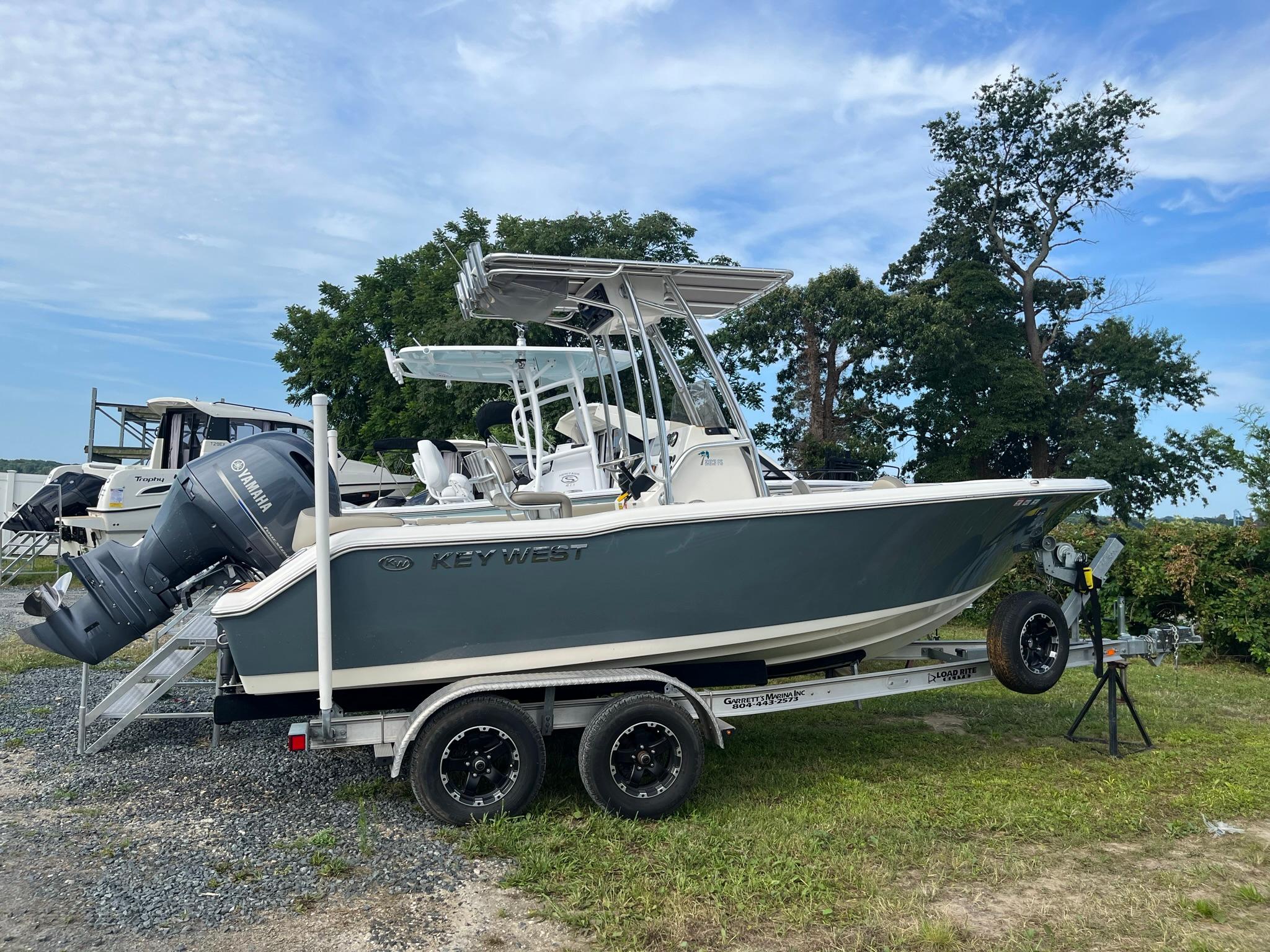 Key West 203 FS 2022 Key West 203 FS boat on trailer, parked outdoors with trees in background.