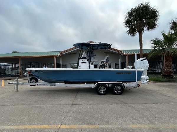 Sea Pro 250 DLX 2024 Sea Pro 250 DLX boat on trailer, parked near palm trees.