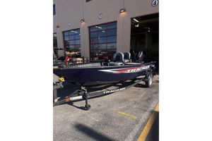 Tracker Super Guide V-16 T 2026 Tracker Super Guide V-16 T boat parked outside a garage.
