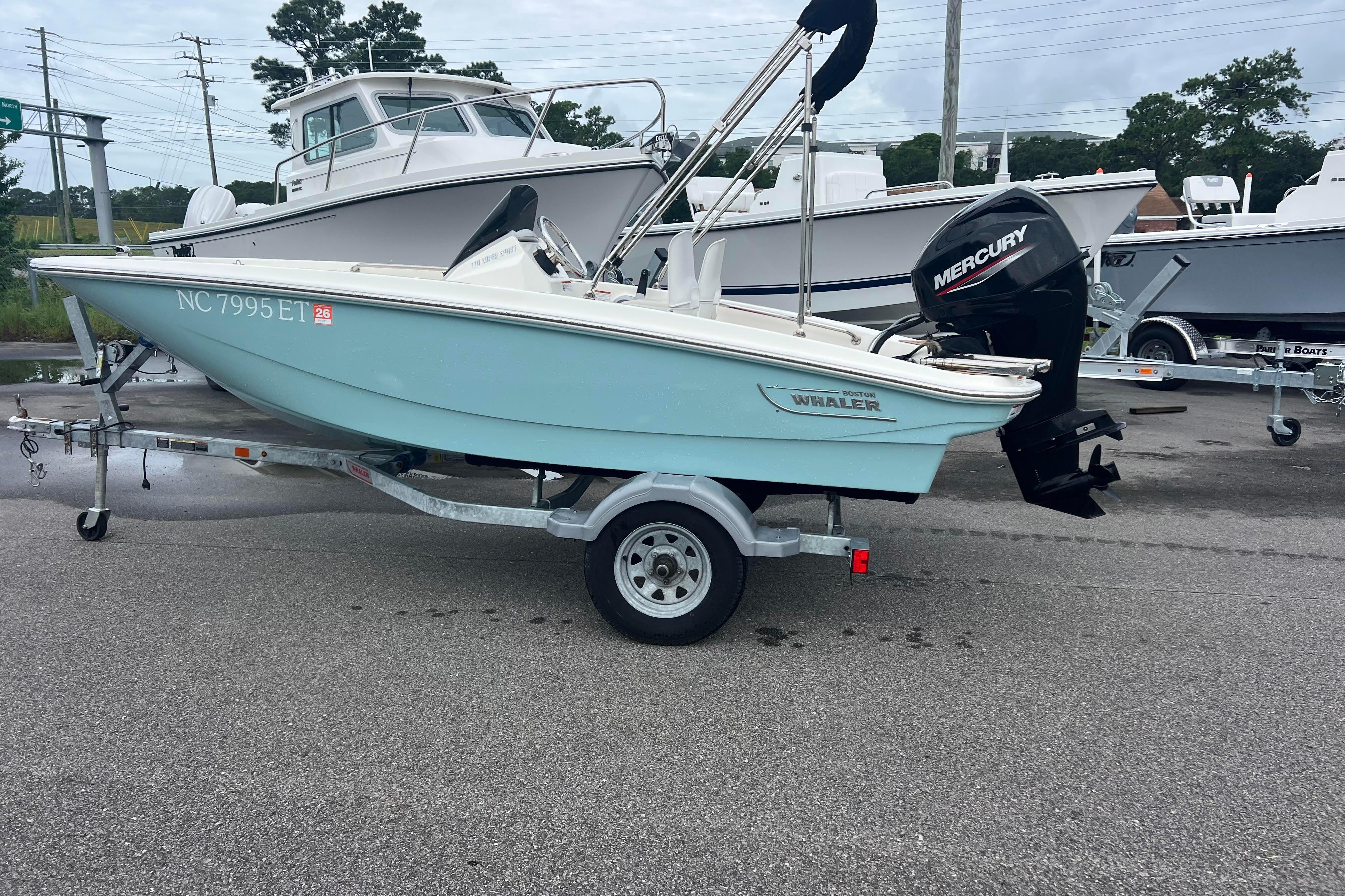 Boston Whaler 130 Super Sport 2021 Boston Whaler 130 Super Sport boat on trailer with Mercury outboard motor.