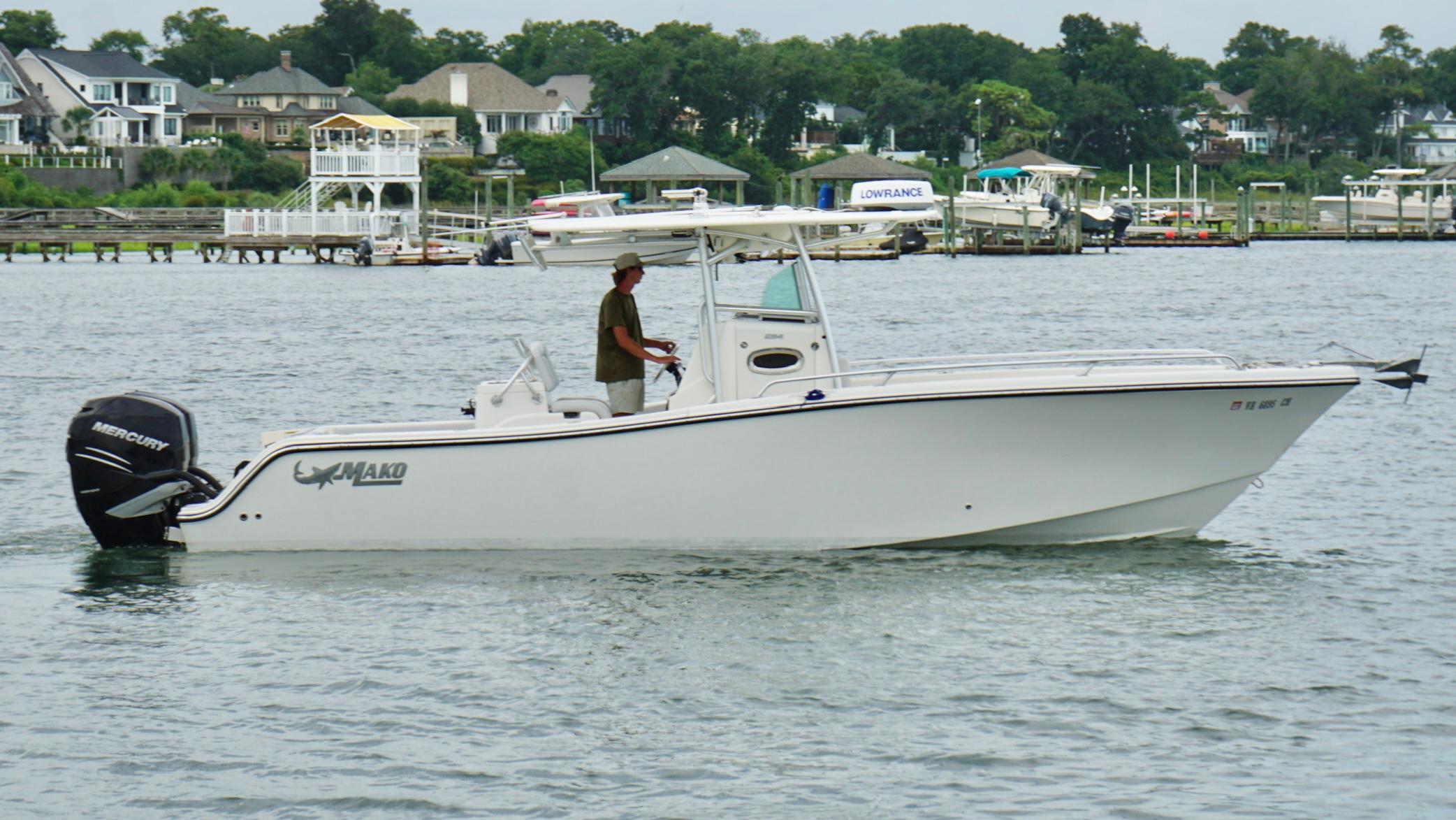 Mako 284 CC 2020 Mako 284 CC boat on water with Mercury engine, near waterfront homes.