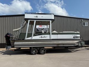 Avalon 2585 CR 2022 Avalon 2585 CR pontoon boat on trailer, parked outside a metal building.