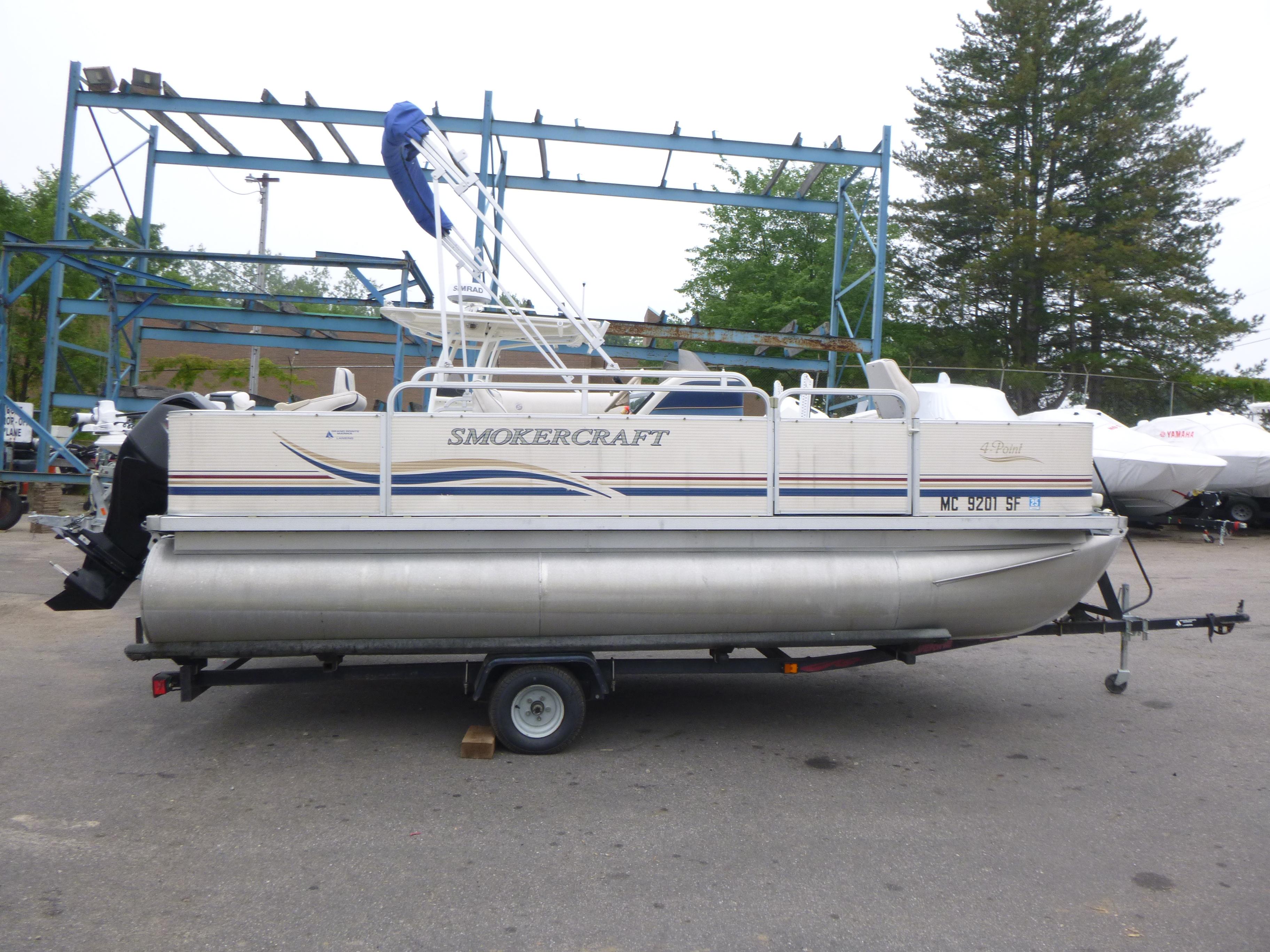 Smoker Craft 818 4-Point 2000 Smoker Craft 818 4-Point pontoon boat on trailer, parked outdoors.