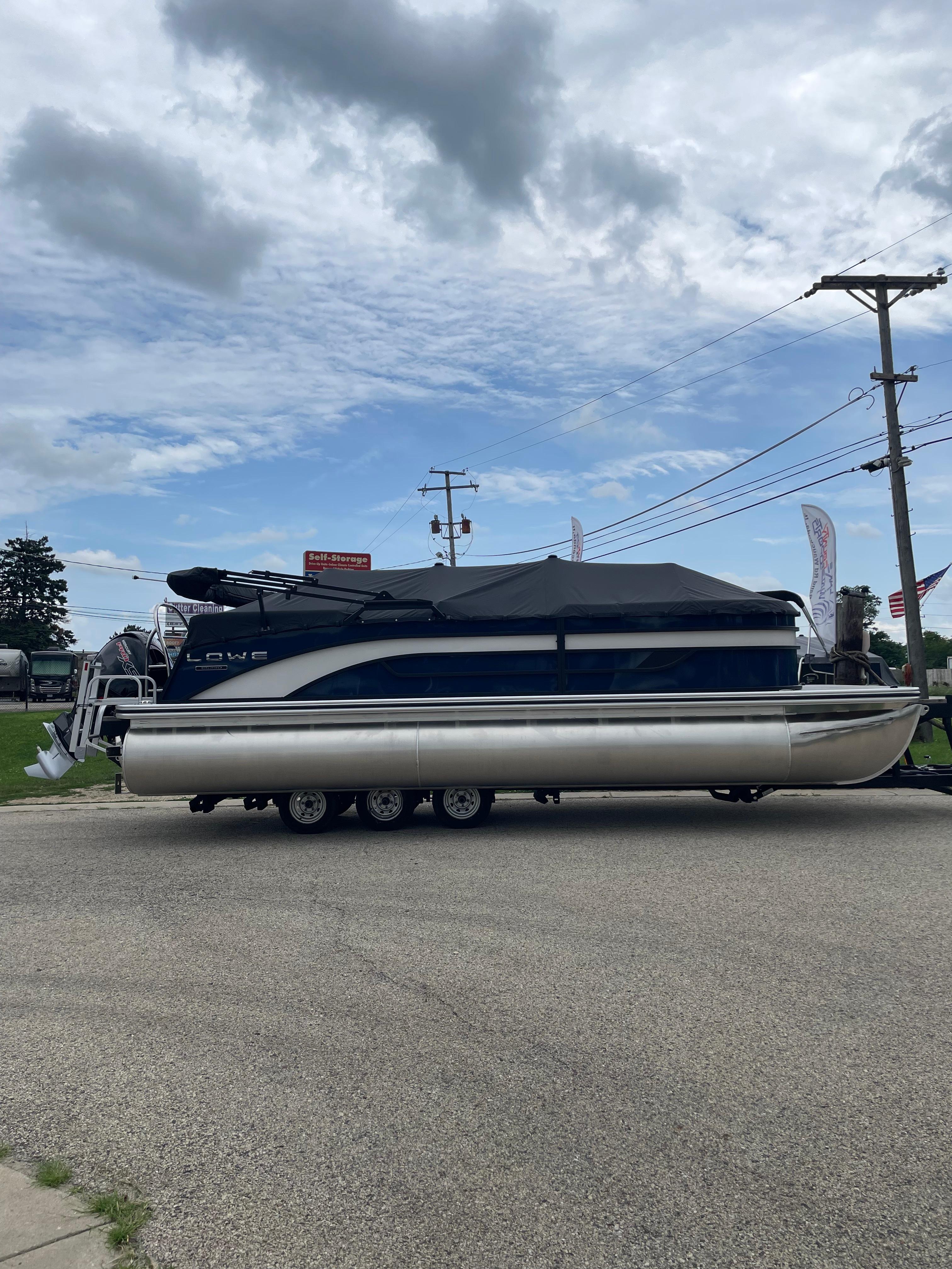 Lowe SS 230 WT Special 2026 Lowe SS 230 WT Special pontoon boat on trailer under cloudy sky.