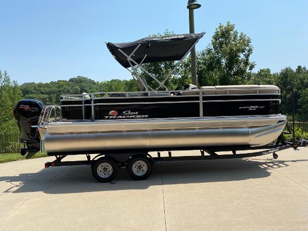 Sun Tracker SportFish 20 DLX 2025 Sun Tracker SportFish 20 DLX pontoon boat on trailer, parked outdoors.