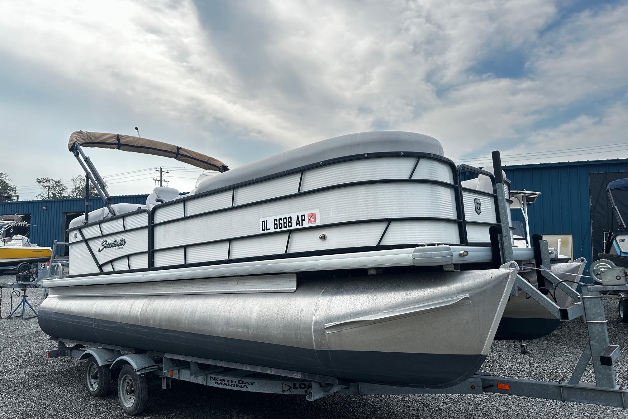 Godfrey Sweetwater 2286 Tri Toon 2017 Godfrey Sweetwater 2286 Tri Toon pontoon boat on trailer, parked outdoors.