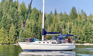 Catalina 34 Sailboat Catalina 34, 1992 model, on calm water with forested background.
