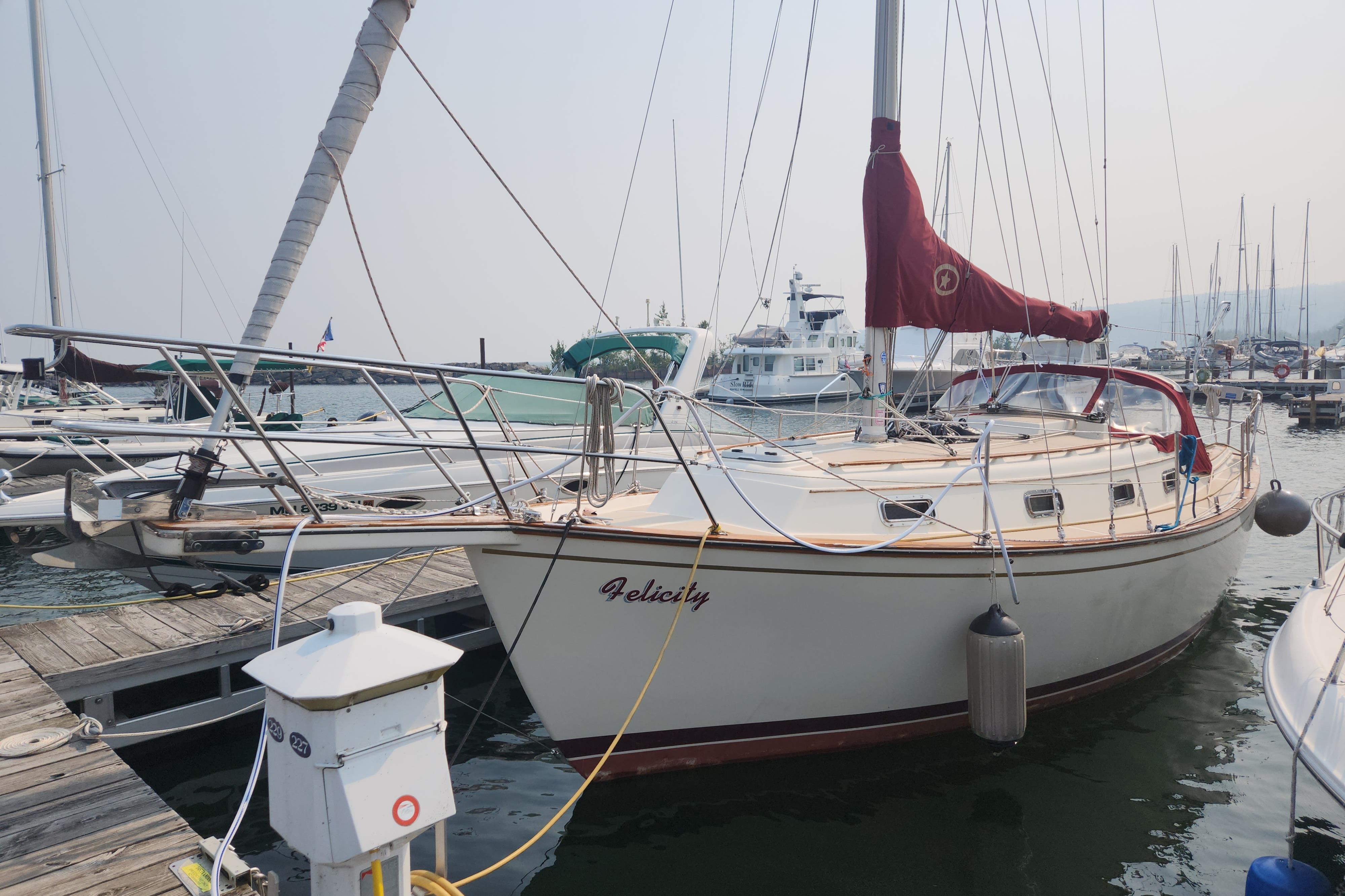 Island Packet 31 Cutter 1989 Island Packet 31 Cutter sailboat docked at marina, featuring red sail cover.