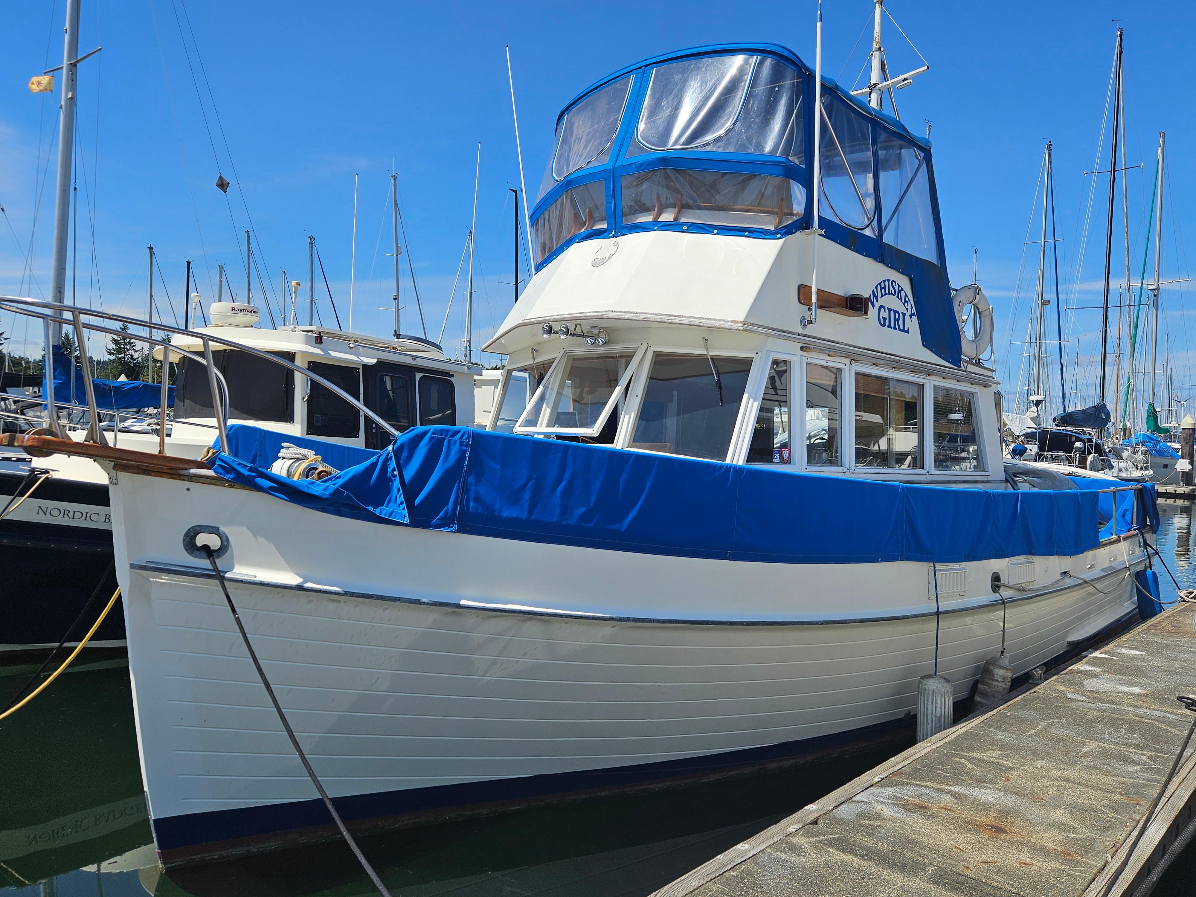 Grand Banks 36 Classic 1973 Grand Banks 36 Classic boat docked, featuring blue covers and a white hull.